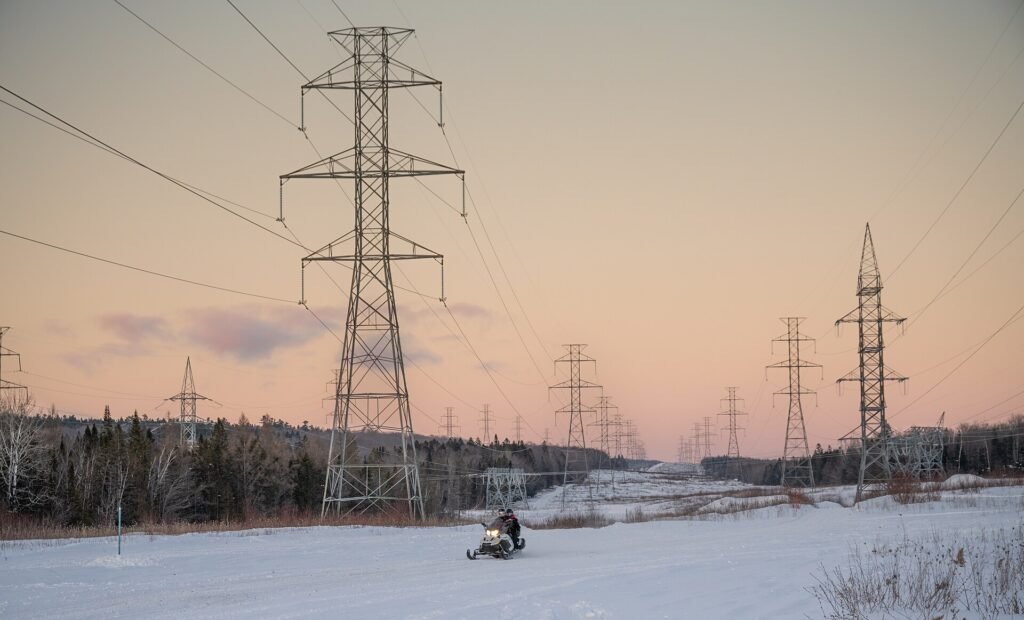 The Grid Is Getting Rebuilt: Transmission Is the Energy Bottleneck Electricity transmission pylons against an evening sky